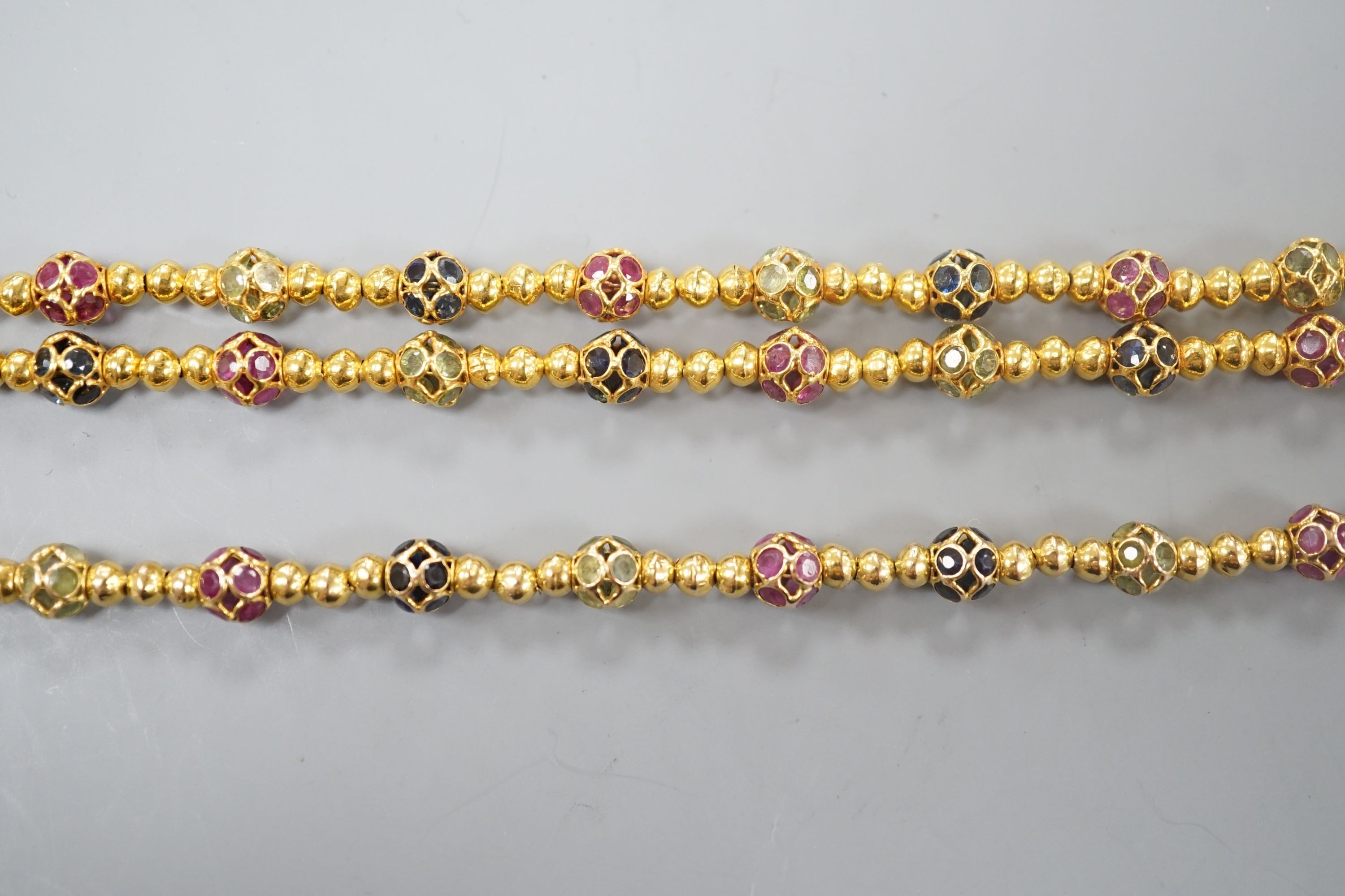 A modern Thai yellow metal and gem set spherical link necklace, 72cm and a similar bracelet stamped 585, 17.5cm, gross weight 35.4 grams.